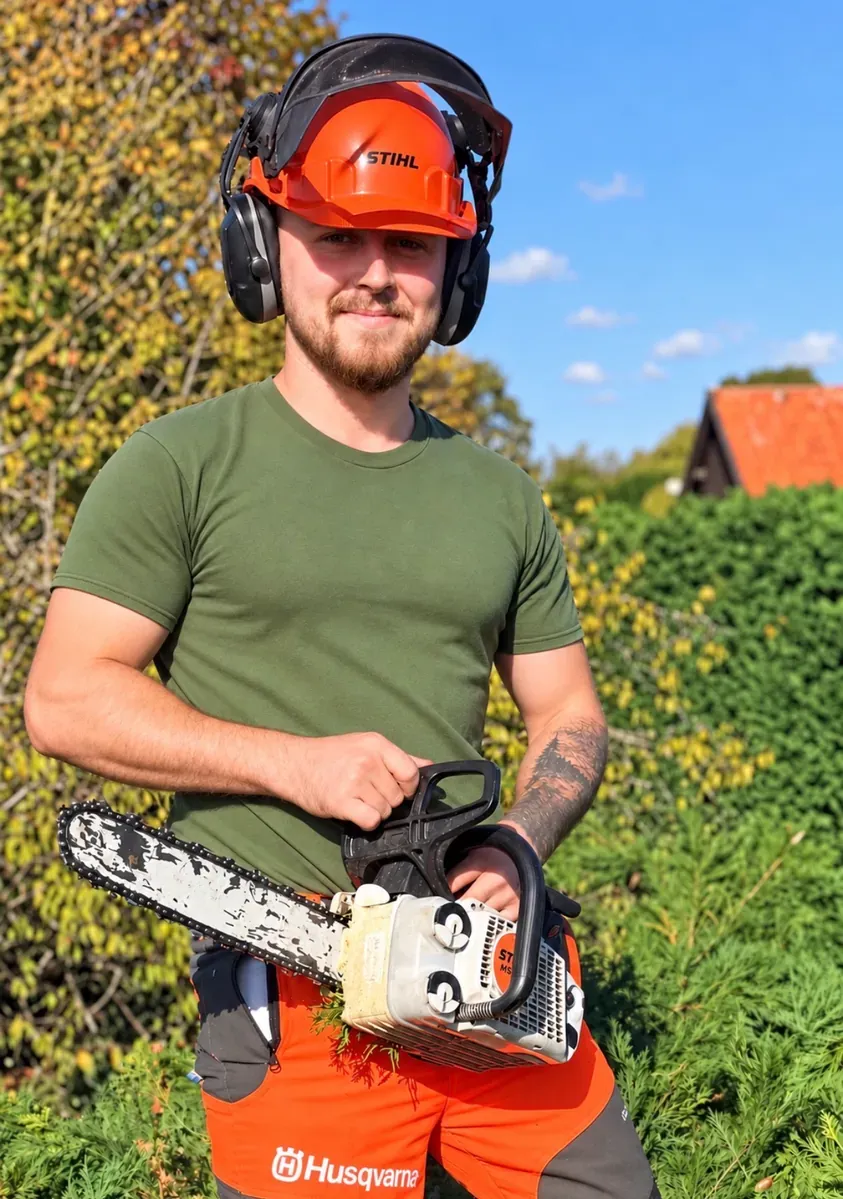 Craig, owner of Foundation Garden and Trees, in safety helmet and ear defenders holding a chainsaw